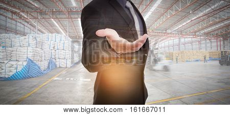Businessman against modern warehousing background with business chance concept.