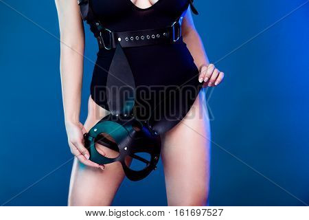 beautiful young sexy woman in bodysuit, baldric and black rabbit mask, posing in studio
