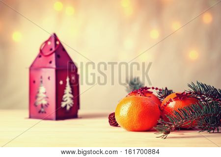 Mandarins with fir-tree branch and house shaped candlestick