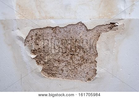 A closeup of a peeling white wall