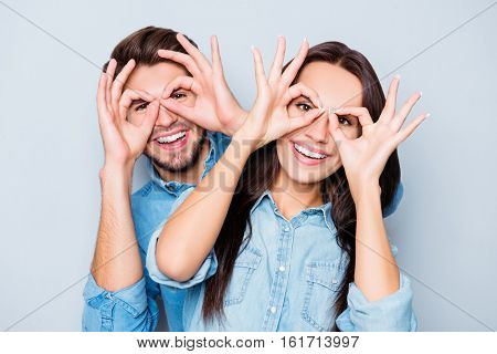 Cheerful Happy Couple In Love Having Fun And Holding Fingers Near Eyes