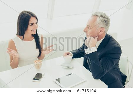 Two businesspeople drinking coffee and discussing business items during lunch