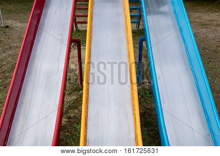 three colourful metal slides in a playground