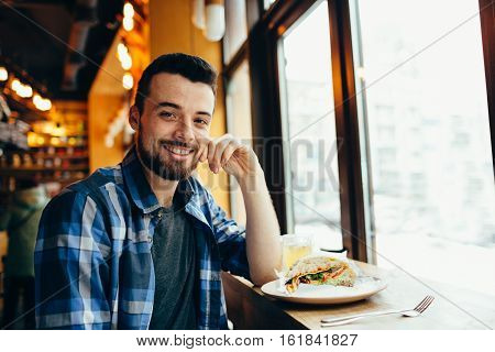 Young Man Having Lunch At Cafe