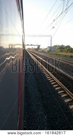 Train stops at the station. Railway track goes over the horizon.