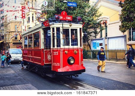 ISTANBULTURKEY - OCTOBER 6 2014: Old-fashioned red tram at the street Istiklal - the most popular destination in Istanbul. Nostalgic tram is the heritage tramway system. It was re-established in 1990 and gained much popularity.