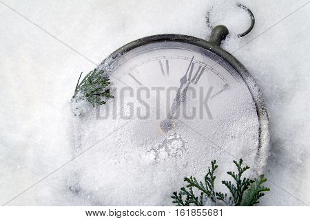 Watch lying in the snow before the new year. Top view