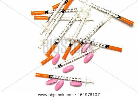 Medical syringe and pink pills isolated on white background