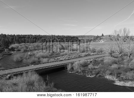 A bridge on Lower Bridge Way in Central Oregon crosses the Deschutes River on a sunny spring day.
