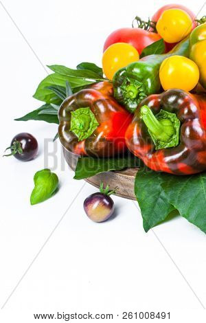 Assorted tomatoes and vegetables isolated on white background. Photo for your design