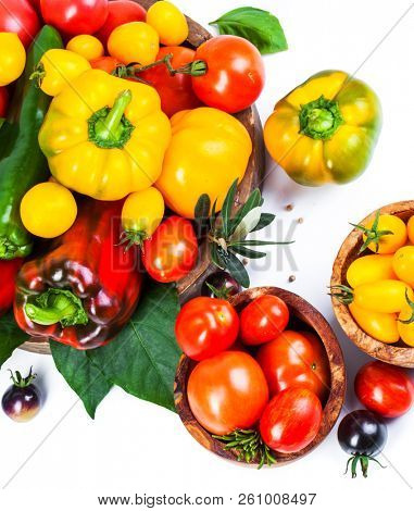 Assorted tomatoes and vegetables isolated on white background. Photo for your design