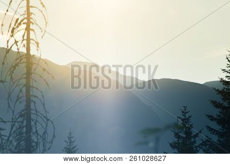 A Dreamy, Hazy Landscape Of A Mountains Close To Sunset. Sun Flase And Misty Look In Blue Tones. Mo