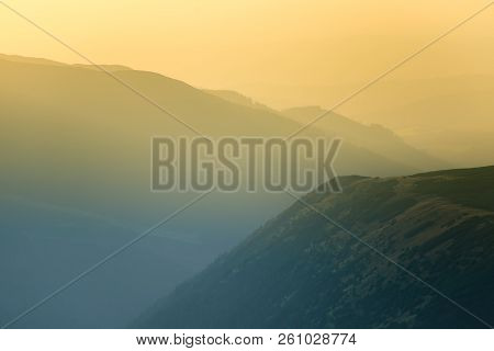A Dreamy, Hazy Landscape Of A Mountains Close To Sunset. Sun Flase And Misty Look In Blue Tones. Mo