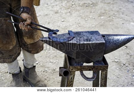 Maniscalco Forge A Horseshoe With The Hammer On The Anvil. Selective Focus