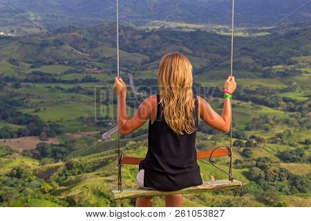 Beautiful Sunburnt Blonde Girl Sitting At The Swing At The Edge Of The Rodonda Mountain Above The Gr