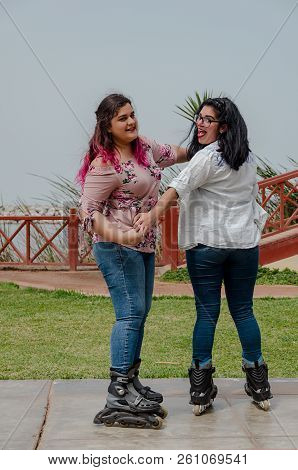 Two Chubby Girls With Inline Skates In The Park