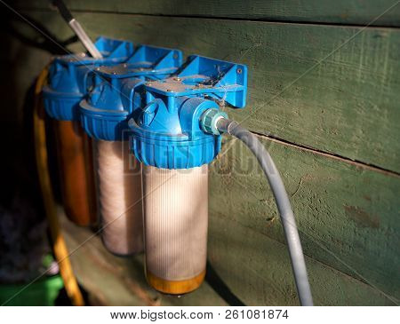 Bunch Of Home Water Filters Mounted On A Wooden Wall, Indoor Closeup