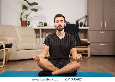 Fit Man Doing Bound Angle Yoga Pose While He's Home.