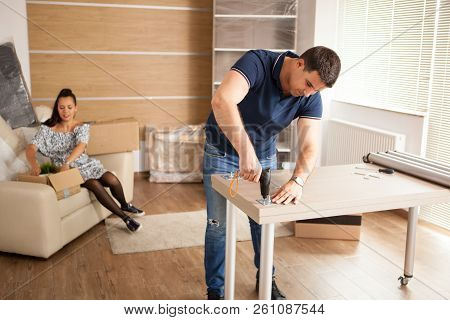 Man Uses Tools To Assembly Furniture In New House.