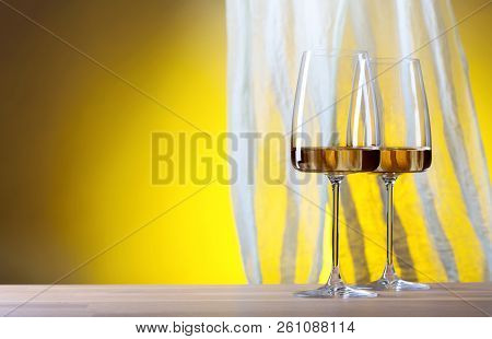 Glasses Of White Wine On A Yellow Background.