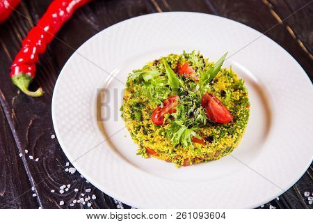 Salad From Bulgur And Fresh Vegetabes On White Plate In Restaurant