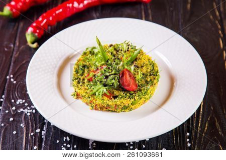 Salad From Bulgur And Fresh Vegetabes On White Plate In Restaurant