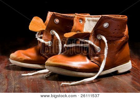 old child's boot on wooden background