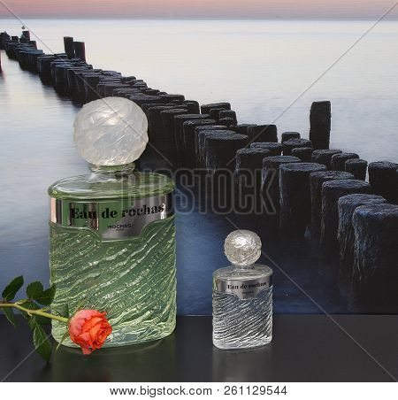 Eau De Rochas, Fragrance For Ladies, Large Perfume Bottle Next To A Commercial Perfume Bottle In Fro