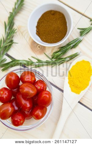 Dry Spices And Herbs In Glass Jar With A Cork, A Bowl Of Cherry Tomatoes And Chili Peppers, White Ba