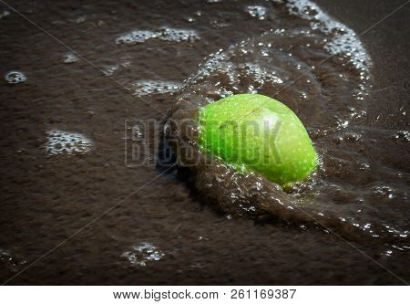 Green Apple In The Sand On The Beach