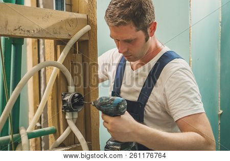 Handsome Male Worker Unmounting An Old Wooden Construction.