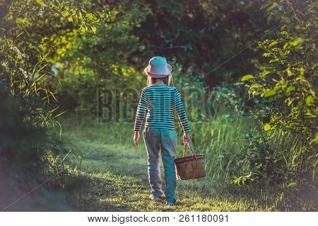 Young Girl Walking On A Path Through Green Woods Carrying A Birchbark Basket
