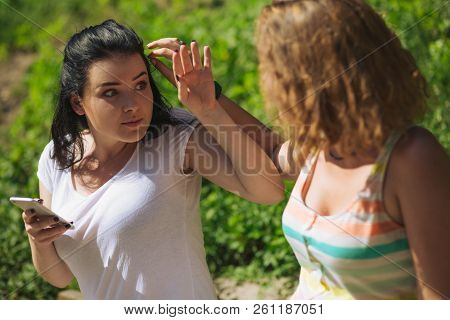 Brunette Girl Is Scared And Surprised Because Her Hair Was Touched. A Girl Help Her Frind To Get A B
