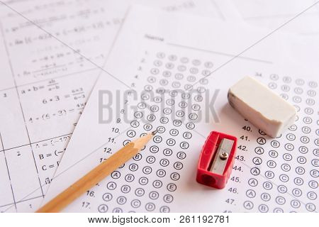 Pencil, Sharpener And Eraser On Answer Sheets Or Standardized Test Form With Answers Bubbled. Multip