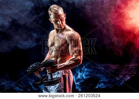 Topless Man Exercising Biceps With Dumbbells Posing In Studio Fuul Of Colored Smoke