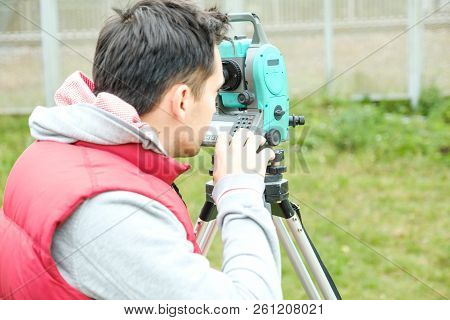Civil Engineer Land Survey With Tacheometer Or Theodolite Equipment. Worker Checking Construction Si