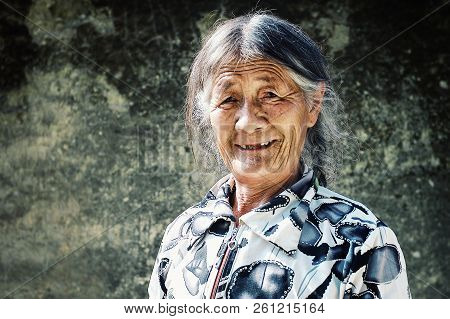 Labrang Monastery, Xiahe, Gansu Province / China - Jun 6 2011: Elderly Pilgrim Woman Enjoying The Ea