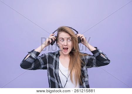 Portrait Of An Emotional Attractive Girl That Pulls Headphones On Her Head. Positive Girl With Headp