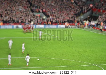 Blurred Background Of Football Players Playing And Soccer Fans In Match Day On Beautiful Green Field