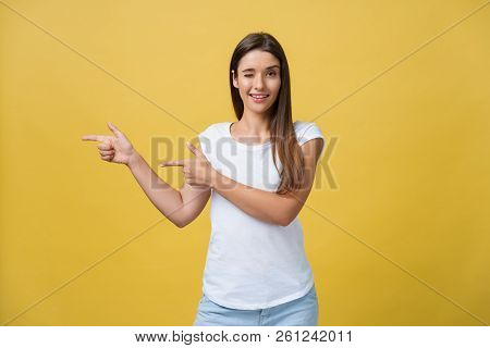 Portrait Of Young Beautiful Female With Perfect Skin Showing Something Interesting At Copy Space Wal