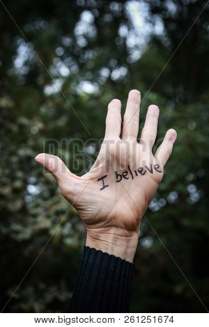 Woman's hand raised with I believe written in marker supporting victims of sexual abuse