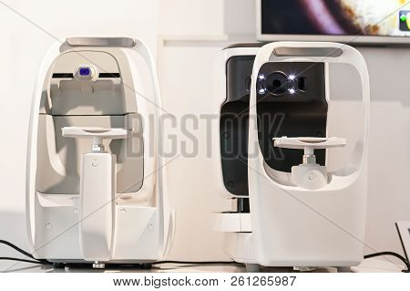 Ophthalmologist Examining Young Man With Optometric Machine In Optics Store
