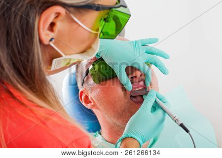 Dentist Using A Professional Dental Laser For Oral Treatment