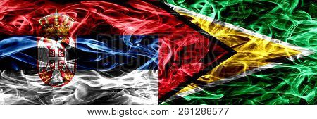 Serbia Vs Guyana, Guyanese Smoke Flags Placed Side By Side. Thick Colored Silky Smoke Flags Of Serbi
