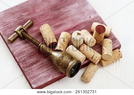 Metal Retro Corkscrew And Heap Used Wine Corks On Wooden Table. Copy Space. Top View. Flat Lay.
