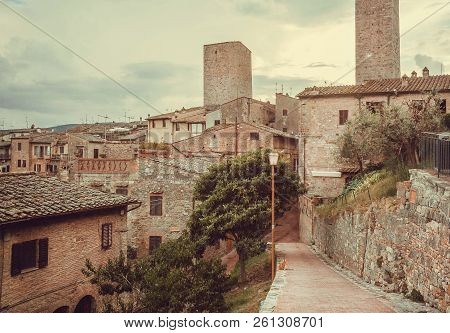 Streets And Gardens Of Italian Medieval Town With Roofs Of Mansions At Evening Landscape Of Tuscany.