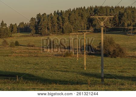 Electric Poles With Sunset Meadows And Forest In Sumava National Park In Autumn Evening