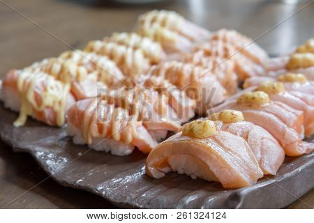 Set Of Salmon Aburi Sushi With Sauce On Plate