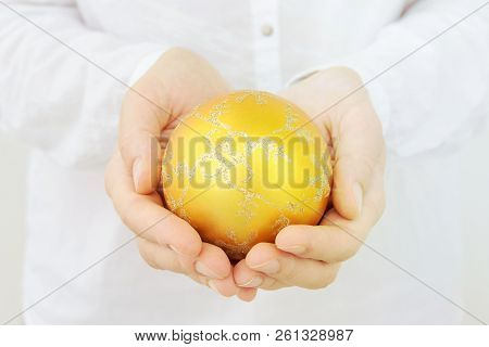 Young Caucasian Woman In White Clothes Holds In Hands Beautiful Big Golden Fir Tree Decorative Glitt