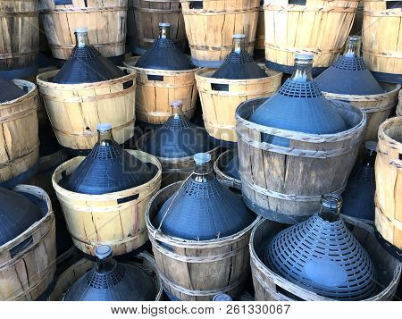 Wine Carboys Bottles Enclosed In Wickerwork Outside At Farm
